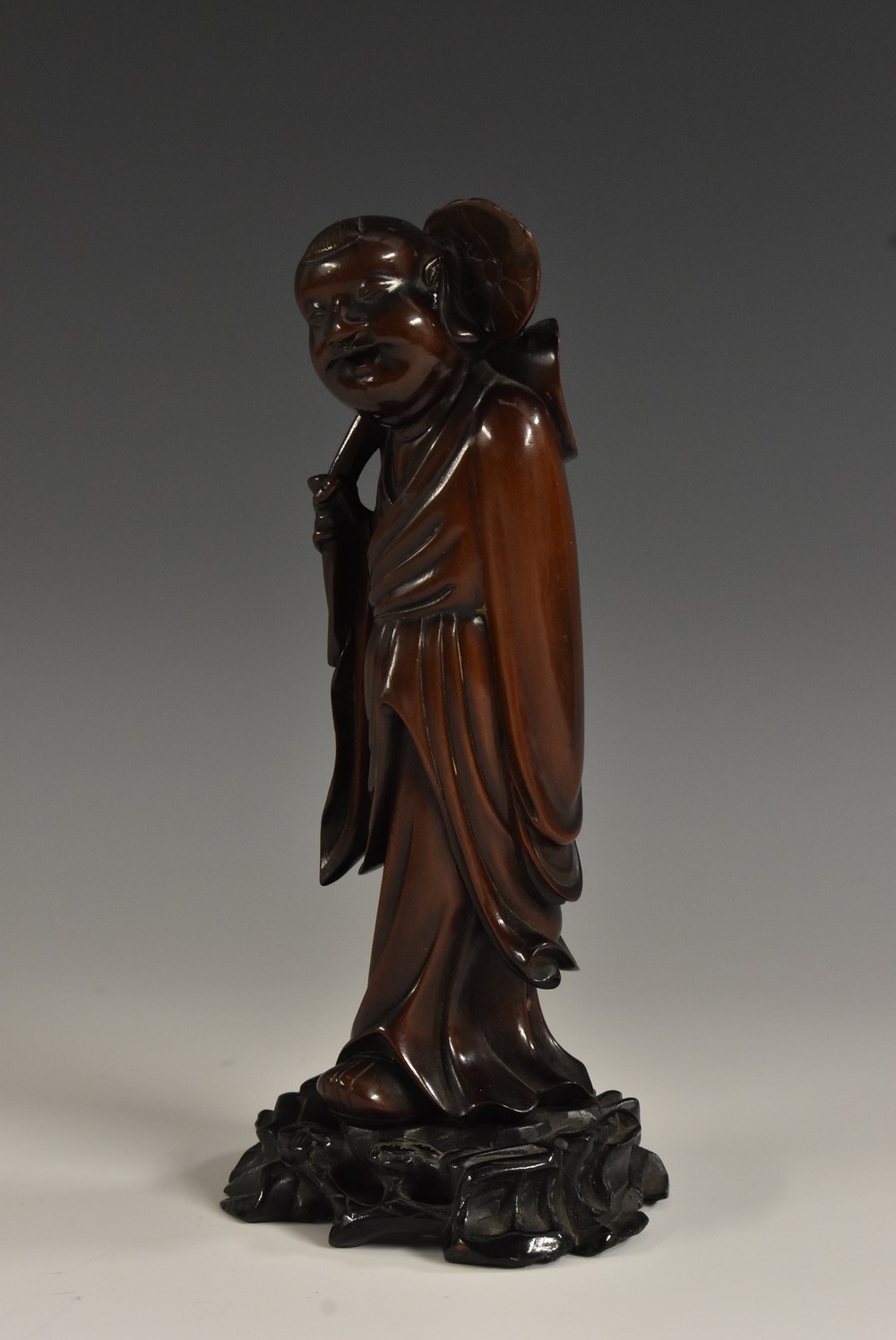 A Chinese hardwood carving, of a Buddhist monk holding a lotus, 18.