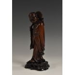 A Chinese hardwood carving, of a Buddhist monk holding a lotus, 18.