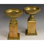 A pair of 19th century Neoclassical gilt-bronze mantel urns, saucer-shaped, beaded borders,