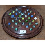 A Victorian mahogany solitaire board, the circular field picked out in polychrome for glass marbles,