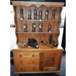 A Farmhouse pine kitchen dresser, outswept cornice above a shaped apron and two plate racks,