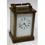 A 20th century brass carriage clock, white enamel dial, folding handle,