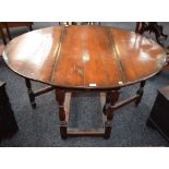 An oak gateleg table, rectangular top with fall leaves, above a frieze drawer, turned supports,