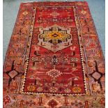 A hand woven Middle Eastern carpet, geometric designs in tones of burgundy ,