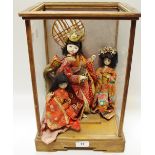 Three Japanese dolls in display case