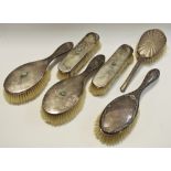An early Edwardian silver backed dressing table set comprising two hairbrushes & two clothes