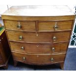 An early 19th century mahogany bow front chest of two short drawers over three graduated long,