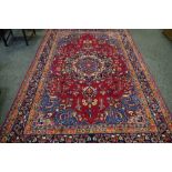 A hand woven carpet, central medallion, floral designs in hues of steel blue,