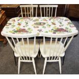 A retro kitchen table with decorative melamine top and spreading tubular legs;