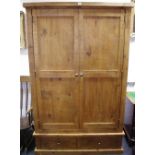 A rustic pine double wardrobe, two panel doors to top,