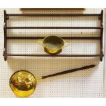 An Ercol wall mounted plate rack; a brass warming pan and two handled pan.