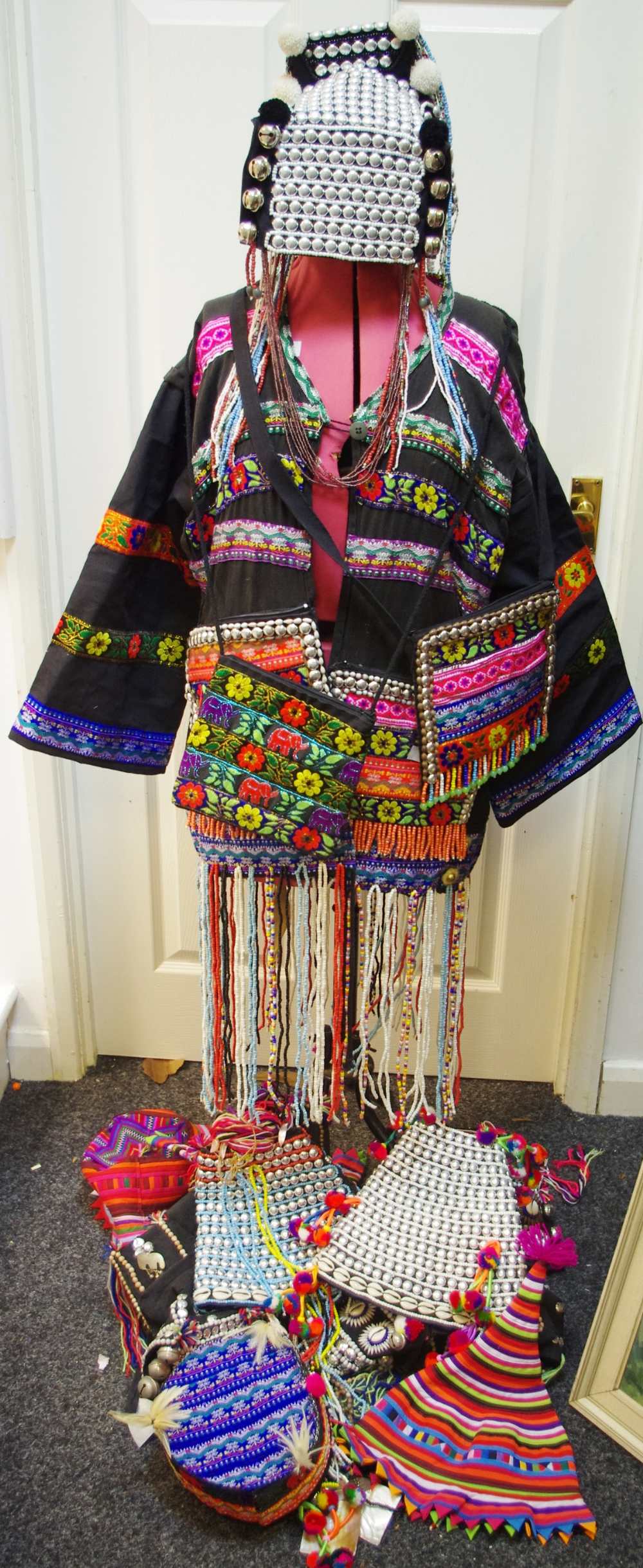 A modern cowrie shell embellished tribal outfit decorated with vibrant bead work and embroidery