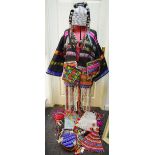 A modern cowrie shell embellished tribal outfit decorated with vibrant bead work and embroidery