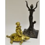 A brass model of a boy on a tortoise;