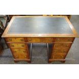 A walnut pedestal desk of small proportions, leather inlaid top,