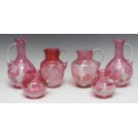 A pair of Victorian Mary Gregory cranberry glass decanters,