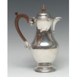 A George V silver baluster hot water pot, hinged domed cover, scroll-capped handle, domed foot,