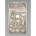 A Chinese silver rectangular visiting card case, chased with temples and deer amongst trees,