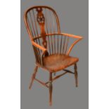A 19th century elm Windsor elbow chair, hoop back with pierced wheel splat, curved arm rail,