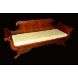 A French Empire mahogany scroll end sofa, shaped back terminating in flowerhead bosses,