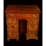 A George III mahogany kneehole desk, rounded rectangular top above a frieze drawer,