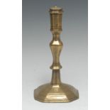 An early 18th century French brass candlestick, panelled sconce, knopped stem,