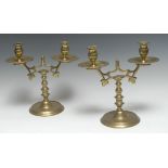 A pair of 19th century brass two-light table candelabra, urnular sconces, broad dished drip pans,