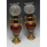 A pair of Louis XVI Revival ormolu-mounted rouge marble ovoid lamps, adjustable burners,