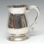 A George II silver bell shaped mug, quite plain, flared rim, acanthus capped double scroll handle,