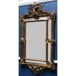 A Rococo style seven panel rectangular wall mirror, gesso mounted with arched putto crest,