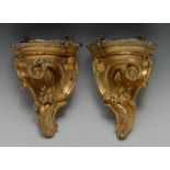 A pair of 19th century giltwood and gesso wall brackets, each shaped plateau above a Rococo scroll,