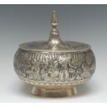 A Persian silver oval box and cover, profusely chased with busy figures in landscapes,