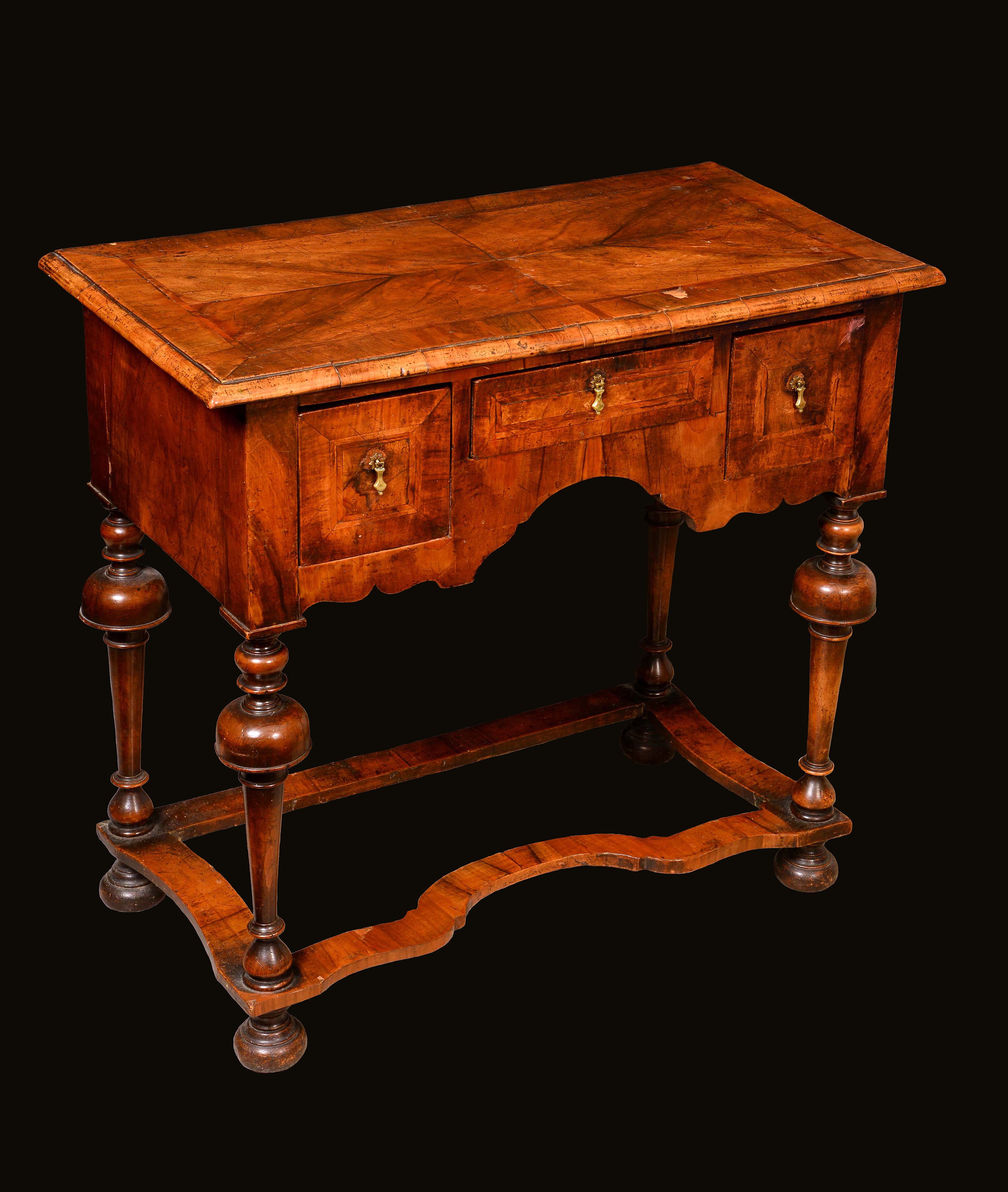 A 'William and Mary' walnut lowboy, quarter-veneered crossbanded top above three frieze drawers,