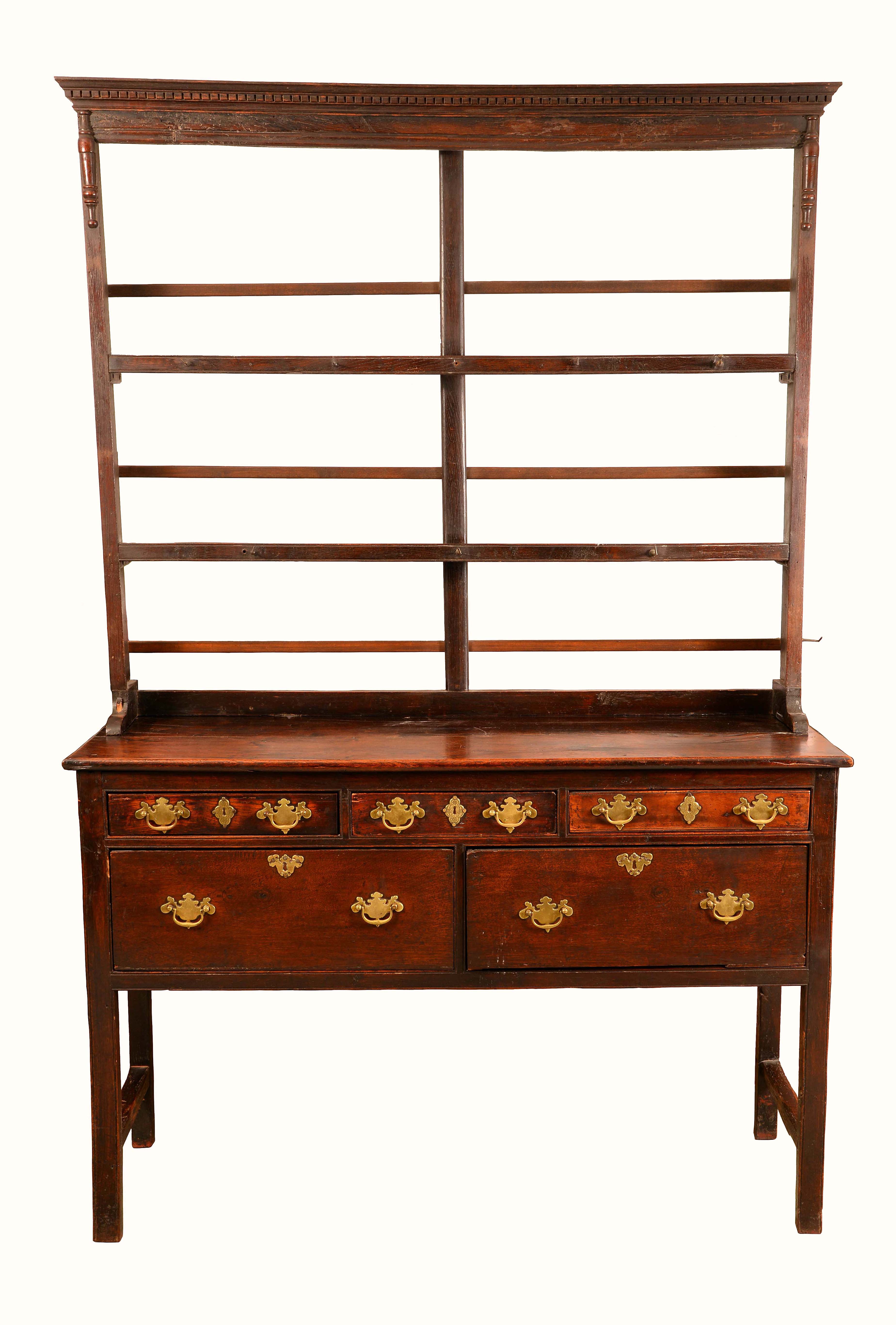 An 18th century oak dresser, the plate rack with dentil cornice above two open shelves,