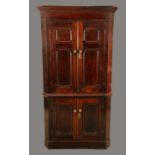 A 19th century oak and mahogany floor standing splay-fronted floor standing corner cupboard,