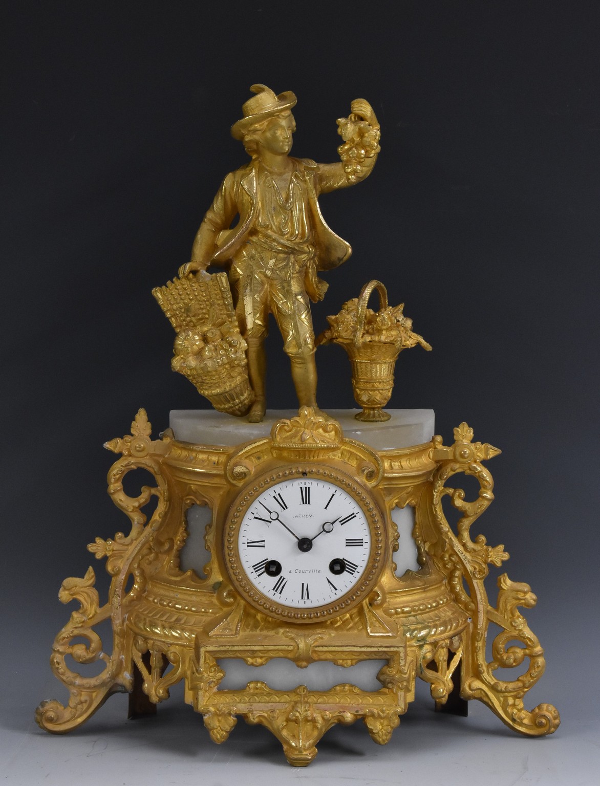 A French figural mantel clock, the 8cm enamelled dial with Roman numerals,