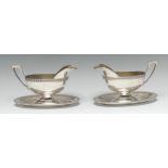 A pair of German silver sauce boats, angular scroll handles, integral stands, palmette borders,
