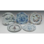 An 18th century Delft circular plate, painted with a stylized Chinese landscape in tones of blue,