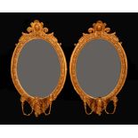 A pair of 19th century giltwood and gesso oval girandoles, each with cartouche shaped cresting,