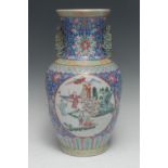 A Chinese Famille Rose temple vase, painted with circular cartouche figures and foliage,