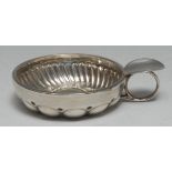 A 19th century French silver wine taster, the circular bowl fluted and embossed with domed reserves,