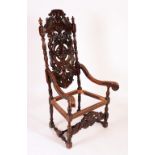 A Carolean Revival oak armchair, the tall back pierced and carved with acanthus bosses and scrolls,