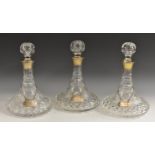 A set of three hobnail and strawberry cut ship's decanters, silver mounted,