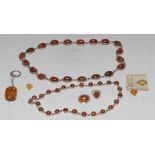 An amber necklace, with twenty oval stones, 60cm long; another, twenty-five stones,