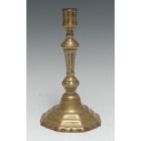 An early 18th century French brass candlestick, of seamed construction, knopped tapered stem,