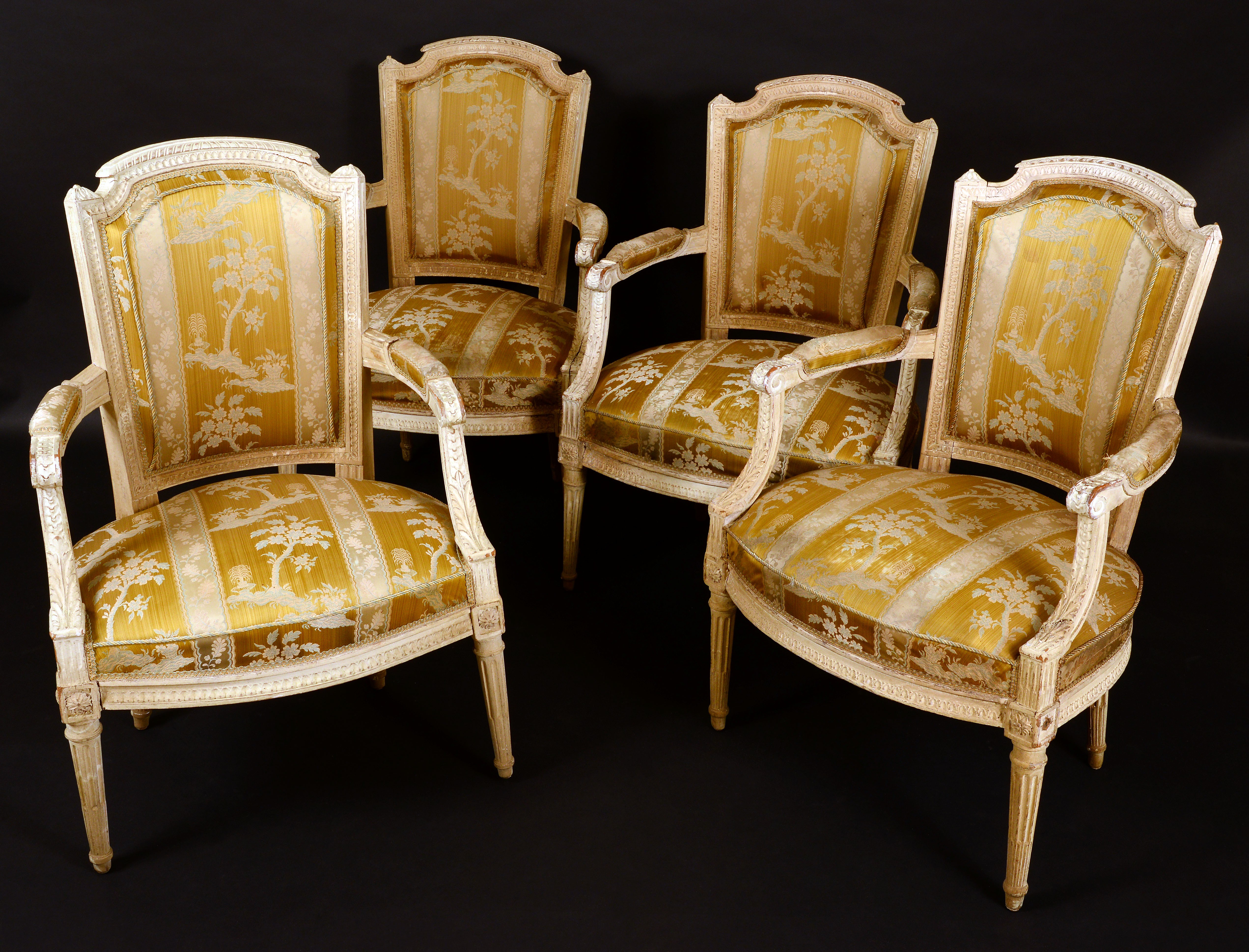 A set of four French fauteuils, of Louis XVI design, tapered backs with arched cresting rails,