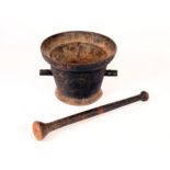 A 19th century cast iron pestle and mortar, flared rim, trunions to side,