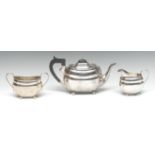 A George V silver three piece boat shaped tea service, comprising rectangular teapot,