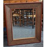 A Japanese red lacquer and rattan rectangular looking-glass, quite plain, centred by a mirror plate,