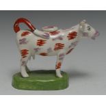 A 19th century Swansea type cow creamer, purple lustre and iron red patches, oval green base, 18.